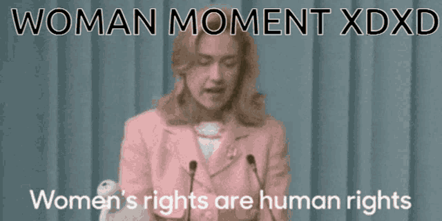 a woman in a pink suit is giving a speech about women 's rights and human rights