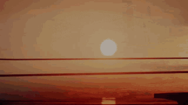 a sunset with the sun shining through the lines of a bridge