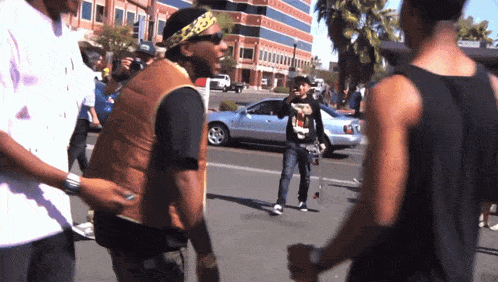 a man wearing a black shirt with a picture of a man on it walks down the street