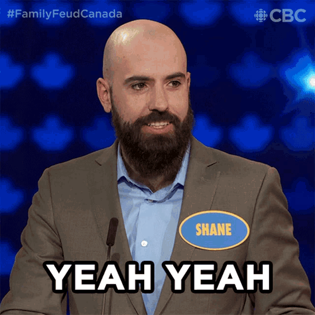 a bald man with a beard is wearing a name tag that says shane