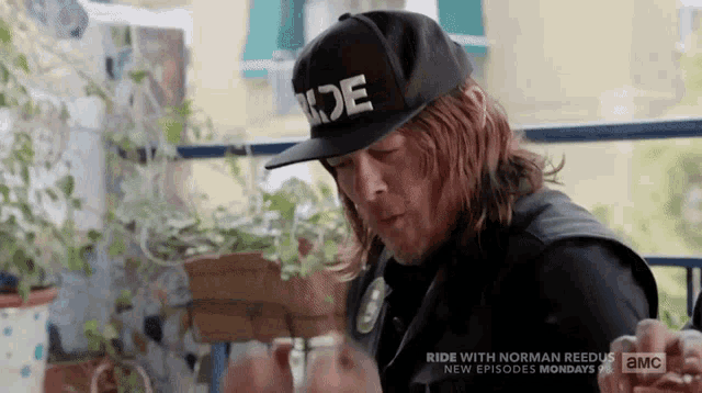 a man wearing a hat that says ride is smoking a cigarette