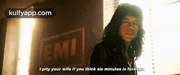 a man is standing in front of a window and talking to his wife .