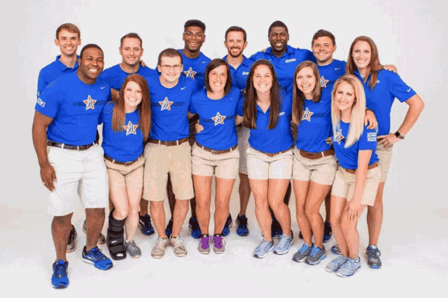 a group of people wearing blue shirts with stars on them pose for a picture