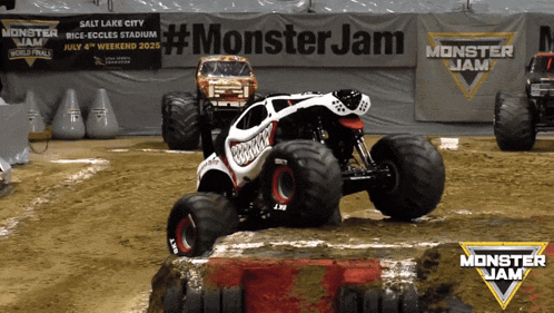 a monster jam sign is behind two monster jam trucks