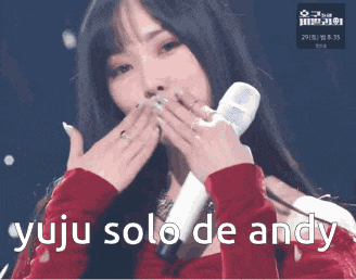 a woman holding a microphone with the words yuju solo de andy written below her