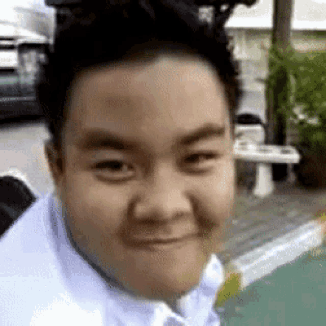 a close up of a man 's face making a funny face while standing next to a pool .