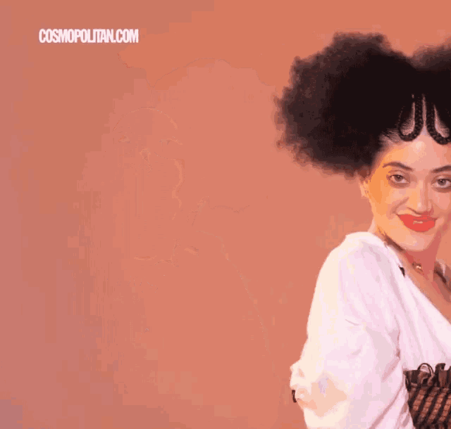 a woman with a big afro is wearing a white shirt and a striped top