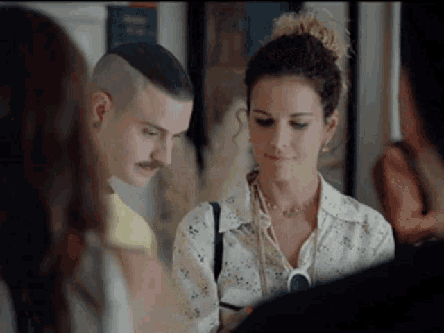 a man with a mustache is looking at a woman