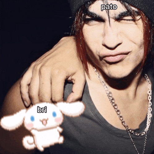 a man with the word pato on his forehead is holding a white cinnamon roll