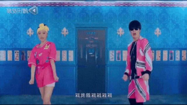 a man and a woman are dancing in front of a blue wall ..
