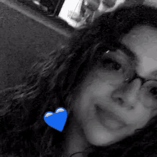 a black and white photo of a woman with a blue heart on her neck