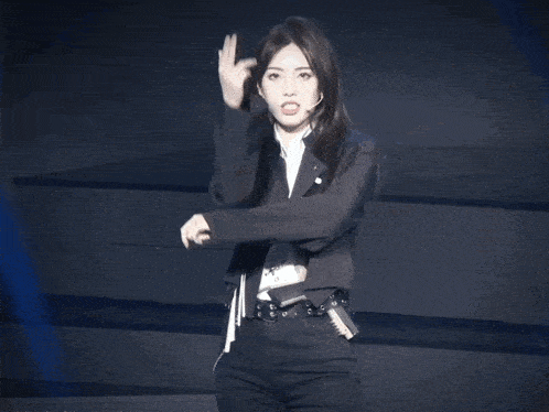 a woman wearing a black jacket and a white shirt is standing on a stage