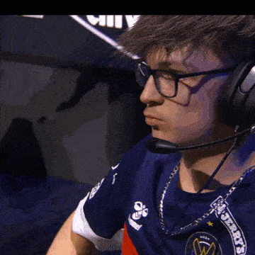 a man wearing glasses and headphones with the word ally on the wall behind him
