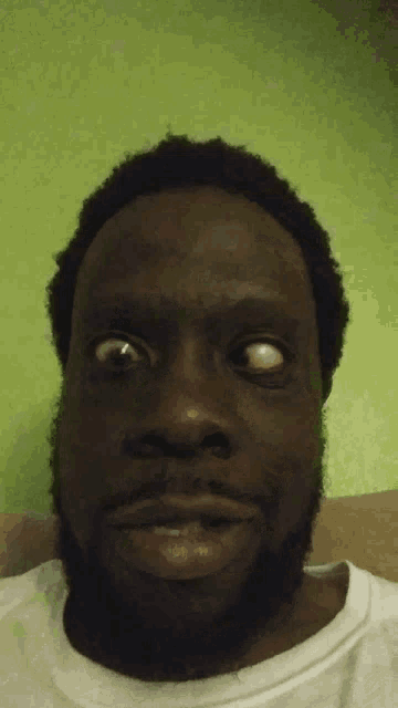 a close up of a man 's face with a green background