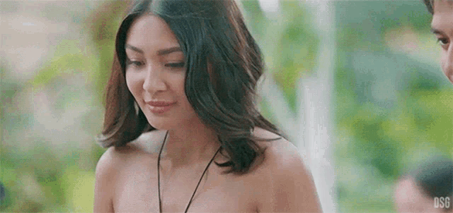 a woman without a shirt is standing next to a man and looking at him .