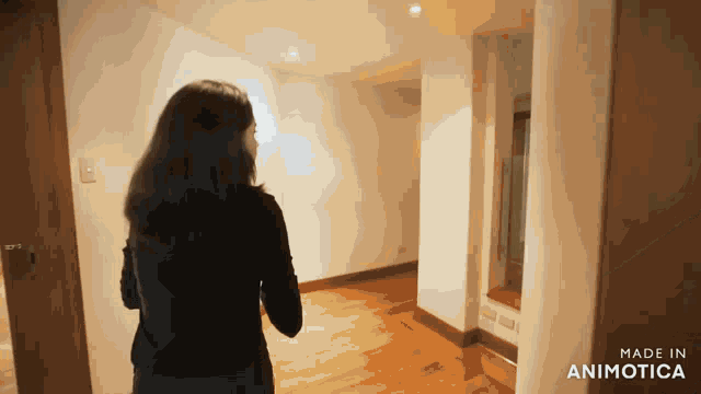 a woman is standing in a hallway with the words made in animotica on the bottom right