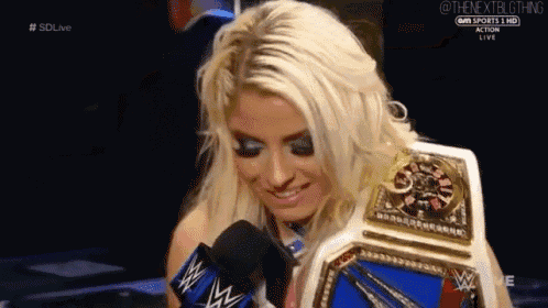 a woman is holding a wrestling championship belt and smiling .