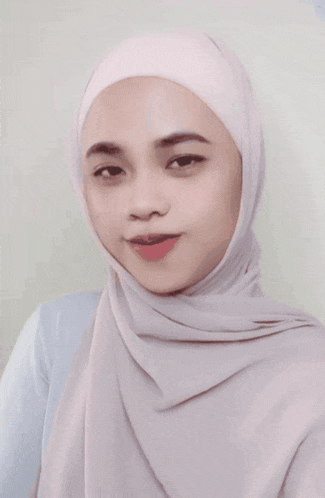 a woman wearing a white hijab and a blue shirt