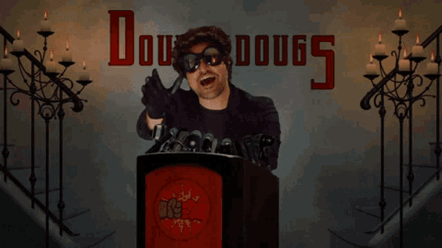 a man stands at a podium in front of a wall that says dougs
