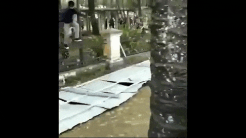 a man is riding a skateboard on top of a pile of cardboard boxes .