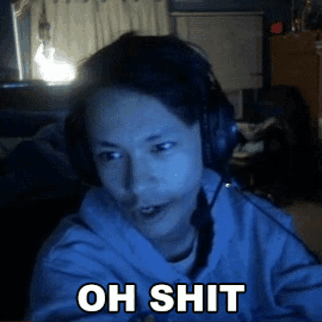 a man wearing headphones says " oh shit " in white letters