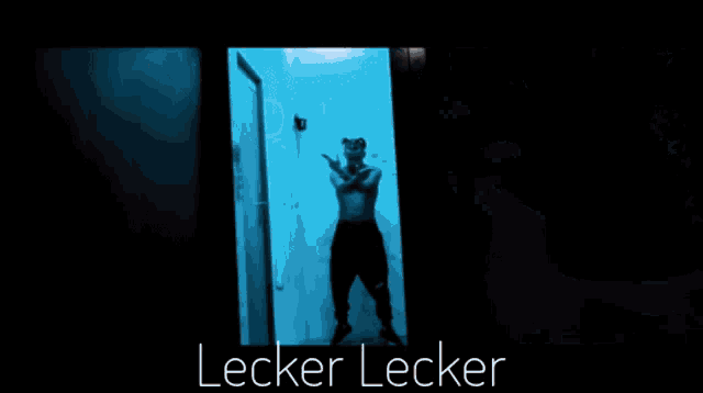 a man in a dark room with the words lecker lecker written below him