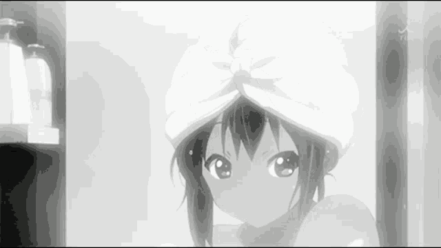 a girl with a towel on her head looks at the camera