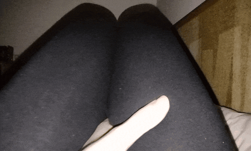 a person laying on a bed with their legs crossed and their hand on their knee