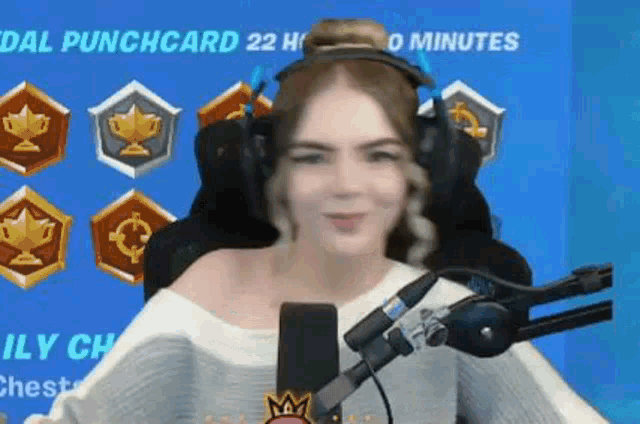 a woman wearing headphones is sitting in front of a microphone and smiling .