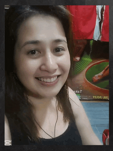a woman is smiling in front of a sign that says ' a ' on it