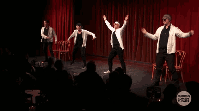 a curious comedy theater logo is displayed on a stage