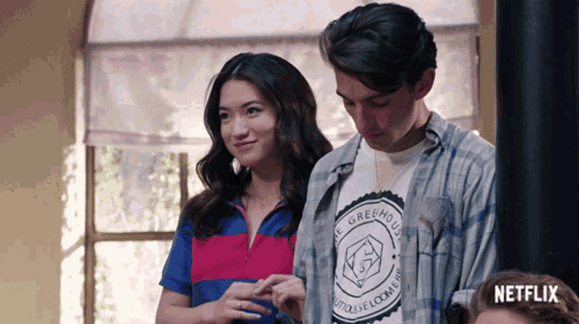 a man and a woman are standing next to each other and the man is wearing a shirt that says " the greenhouse "