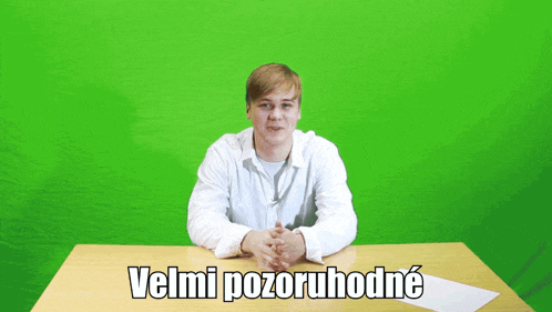 a man sitting at a desk with velmi pozoruhodne written on the table