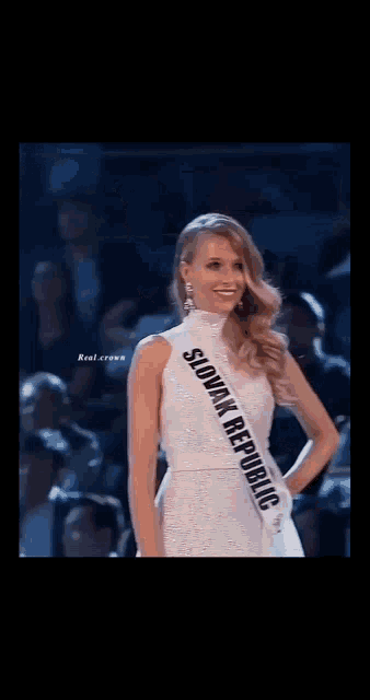 a woman is wearing a sash that says spain on it .