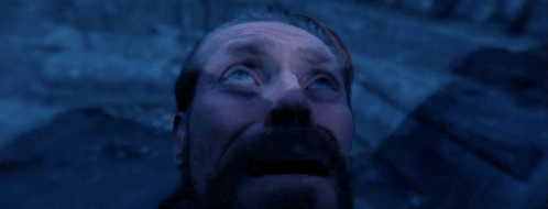 a man with a beard looks up into the sky