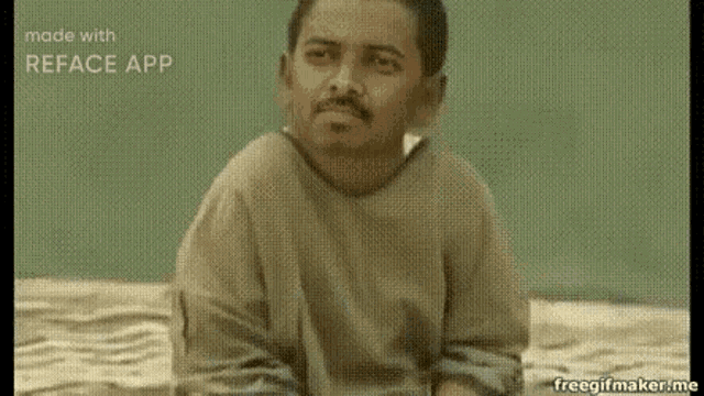 a man with a beard and mustache is sitting on the ground .