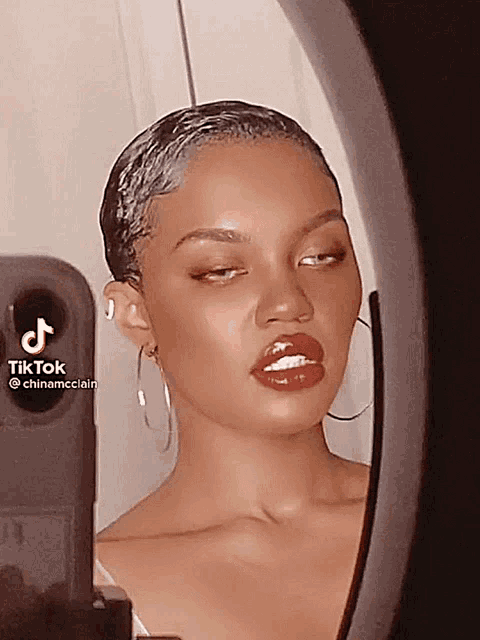 a woman is taking a picture of herself in a mirror with a tik tok watermark