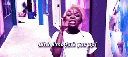 a woman is standing in a hallway and says bitch i 'm a fuck you up .