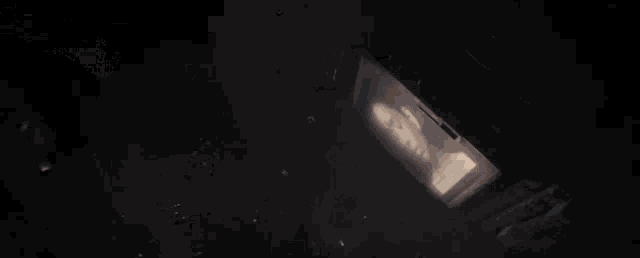 a painting of a woman 's face is projected on a wall in a dark room .