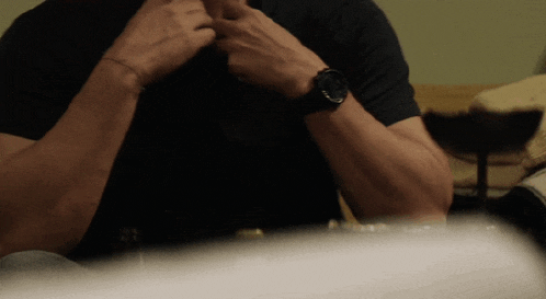 a man wearing a black shirt and a watch on his wrist