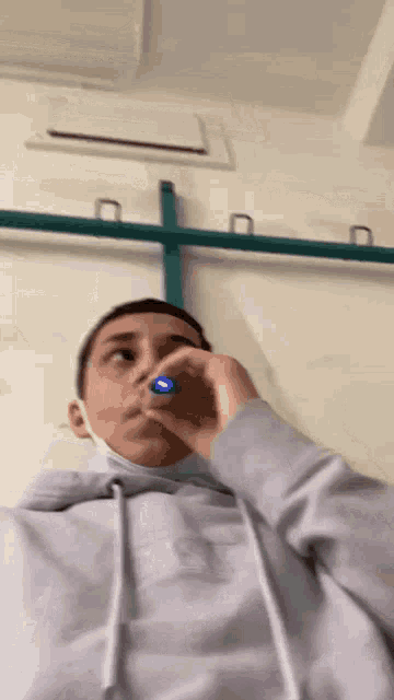 a person wearing a mask is holding a blue pen