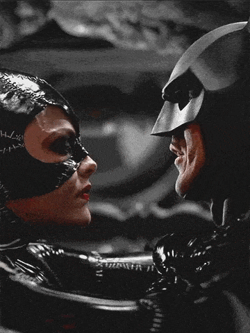 catwoman and batman are kissing in a black and white photo