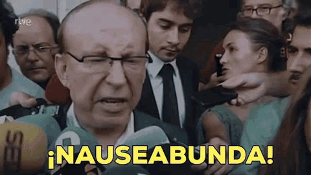 a man in a suit and tie is surrounded by microphones and the word nauseabunda is above him