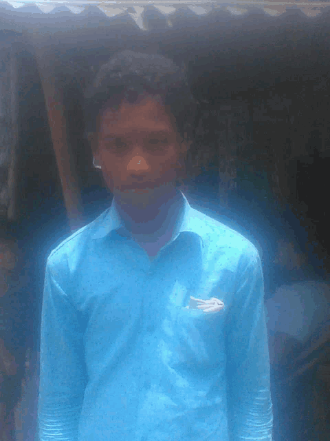 a young man in a blue shirt with a white arrow in his pocket