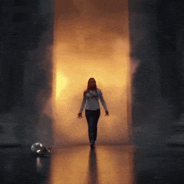 a woman is walking through a doorway with smoke coming out