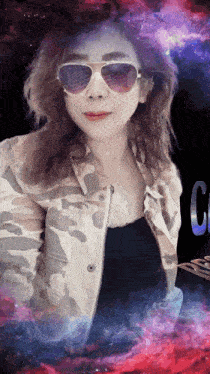 a woman wearing sunglasses and a camouflage jacket stands in front of a galaxy