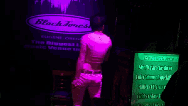a woman is dancing in front of a screen that says black forest