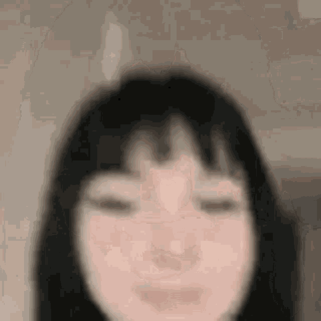a close up of a woman 's face with her eyes closed and a blurry background .