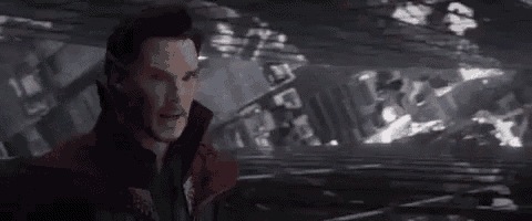 doctor strange is standing in front of a building in a dark room .