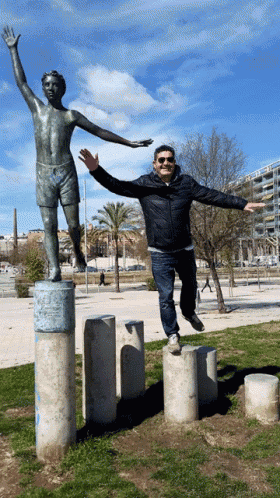 a man is jumping in front of a statue of a man